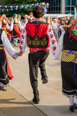Man in traditional red vest dancing during cultural festival