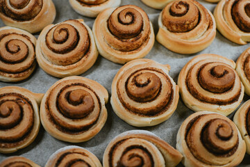Close-up cinnabon buns freshly baked in the oven before applying cream in a cafe