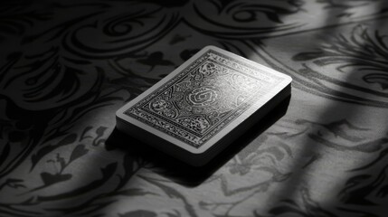 Fototapeta premium A single playing card with a detailed design lies on a patterned surface.