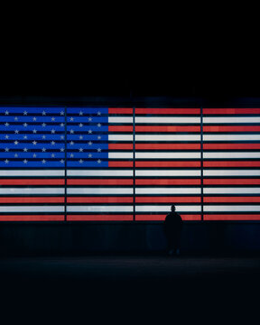 Glowing American Flag LED Display at Night in Times Square, NYC with Solitary Silhouette