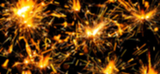 Naklejka premium Sparkler spark. Firework spark or blurred light sparkler. New Year banner or Christmas background. Christmas spark and New Year sparkler on black background. Spark fire at black background. Blurred