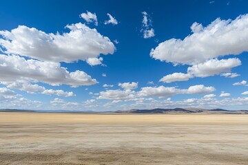 Fototapeta premium Expansive Desert Landscape Under a Bright Blue Sky with White Clouds