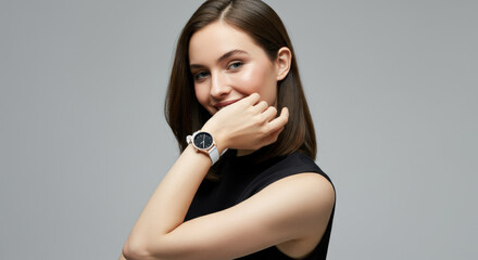 Fototapeta premium Smiling Caucasian woman showing wristwatch, stylish in black top