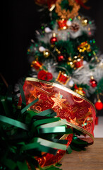 Christmas decoration detail. Red and gold, decorations such as ribbon, fir branches and pine cones.