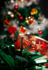 Christmas decoration detail. Red and gold, decorations such as ribbon, fir branches and pine cones.