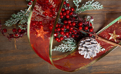 Christmas decoration detail. Red and gold, decorations such as ribbon, fir branches and pine cones.