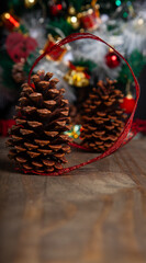 Christmas decoration detail. Red and gold, decorations such as ribbon, fir branches and pine cones.