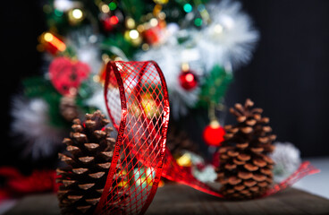 Christmas decoration detail. Red and gold, decorations such as ribbon, fir branches and pine cones.