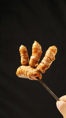 turmeric tamarind herbal drink in a plastic bottle, and turmeric on a plain black background