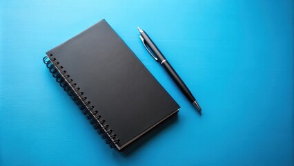 Black notebook and pen resting on a blue table, black, notebook, pen, blue, table, office supplies