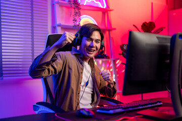 Asian handsome young e-sport man gamer play video game on computer.  © Pavitra