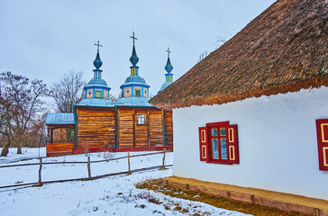 The whitewashed hata house and timber church in Pereiaslav Scansen, Ukraine