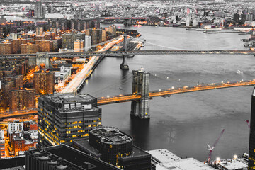 a rooftop view in New York City overlooking the Brooklyn bridge, Manhattan bridge, and FDR drive at night, shot from the financial district looking uptown.