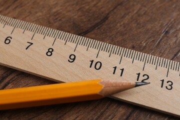 Ruler and pencil on wooden table, closeup