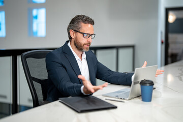 Naklejka premium Surprised 40s business man working with laptop in office. Surprised business man director using laptop. Surprised manager at office workplace. Surprised Ceo office workers business people at office.
