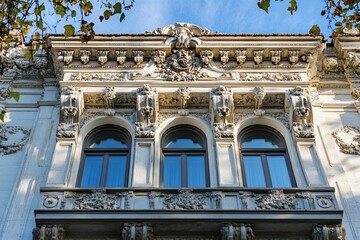 Obraz premium Ornate facade with three arched windows and intricate carvings.