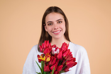 Beauty girl with tulip. Beautiful sensual woman hold bouquet of tulips, studio portrait on beige background.