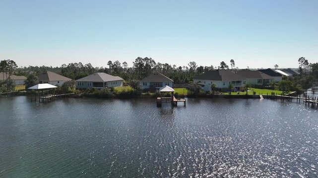 Flying Away From Boat House Lifts With Waterfront Houses By The Lake In Panama City Beach, Florida, USA. - aerial pullback shot