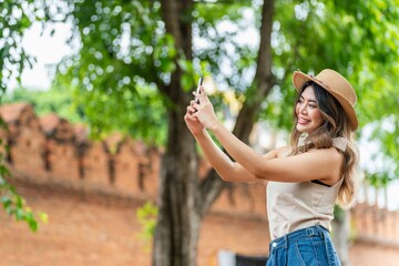 Asian Tourist Woman Using Phone In Front Tha Phae Gate of Chiang Mai, Thailand