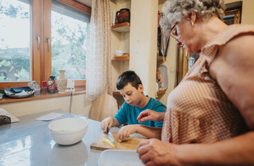 An elderly woman and young boy engage in a cooking activity, surrounded by a warm, inviting kitchen environment. The scene conveys family bonding, warmth, and inter generational connection.