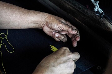 a old lady is weave a Samarinda sarong in Kampong Tenun, Samarinda