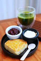 Scone and Jam with Clotted Cream Cheese Serving with Hot Matcha Drink in Menu Set.
