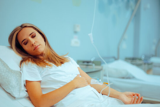 Patient Resting in Hospital Bed with IV Cannula in her Hand. Anemic woman feeling sick from iron deficiency 
