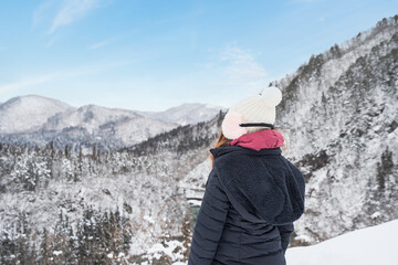 Young woman traveler looking at beautiful landscape in winter