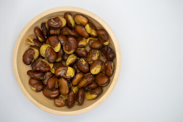 Koro beans in a wooden bowl on a white background