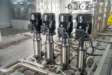 Industrial interior of water pump, valves, pressure gauges, motors inside engine room. Valve and pumps in an industrial room. Urban modern powerful pipelines and pumps, automatic control systems