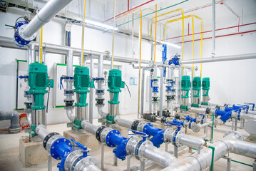 Industrial interior of water pump, valves, pressure gauges, motors inside engine room. Valve and pumps in an industrial room. Urban modern powerful pipelines and pumps, automatic control systems