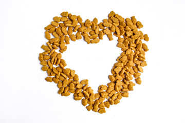 Pile of dry cat food in heart shape isolated on white background