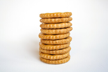Stack of sandwich biscuits filled with peanut butter flavored cream on a white background