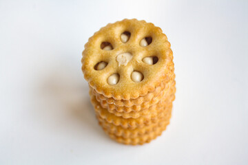 Stack of sandwich biscuits filled with peanut butter flavored cream on a white background