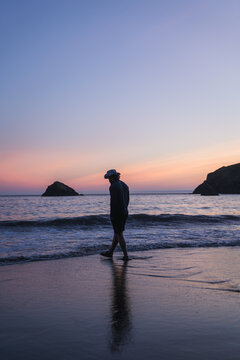 Cowboy walking on the beach at sunset in California