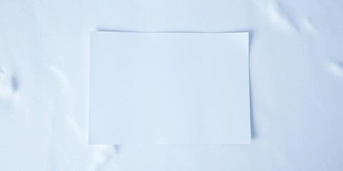 A pristine white sheet of paper lies flat on a snowy surface, untouched and unblemished., smooth, isolation, surface