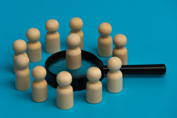 Obraz premium Wooden figures on top of two magnifying glass. Focusing on the few, amidst the many. A powerful symbol of finding the right talent. Beyond the crowd. 