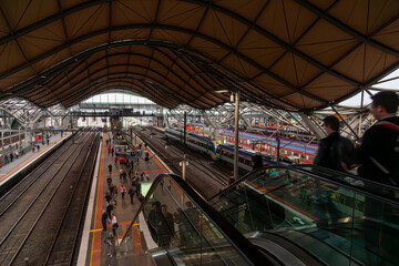Southern Cross Station in Melbourne with modern architecture, trains, and bustling commuters