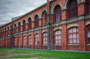 Historic red brick building with arched windows and iron bars in Melbourne, Australia