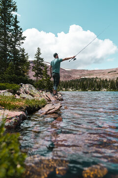 Man casting with a fishing rod in mountain lake