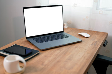 Open laptop with blank screen on a wooden desk in a kitchen room home office