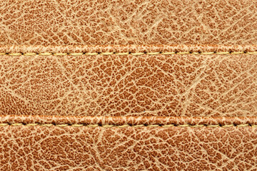 Close-up Stitching on brown synthetic leather texture.