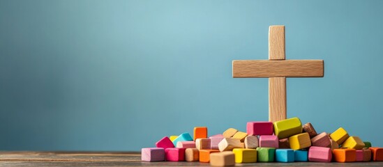 Wooden cross surface pile colorful blocks scattered around Christian themed craft supplies