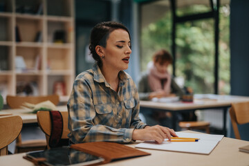 A focused student participates in class activities inside a cozy and inviting classroom setting, fostering an engaging learning experience.