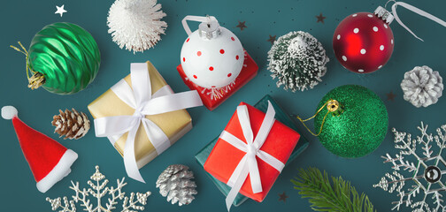 Gift boxes with christmas balls and tree decor on green background