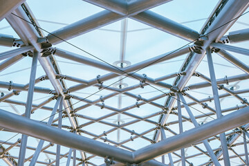 Unique structural design showcasing intricate metal framework beneath a clear sky in a modern...