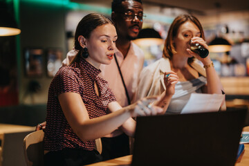 A diverse group of business professionals engaged in brainstorming and strategic planning during a late night meeting. They are collaborating intently while reviewing documents and discussing ideas.