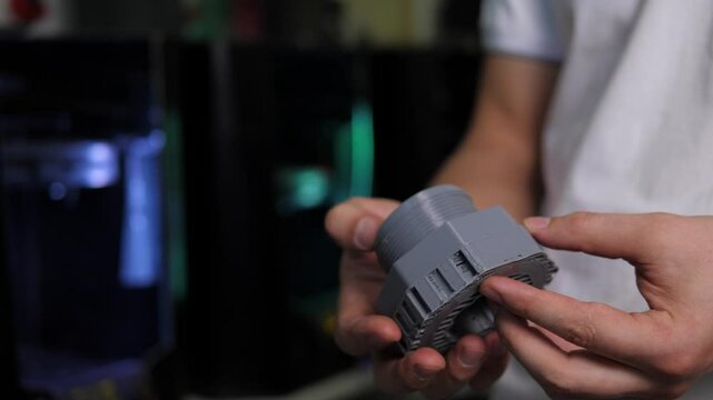 A man holds figures created on a 3D printer in his hands. 3D technology. Models printed on a 3D printer made of hot molten plastic. The object was created on a high-tech digital printer.