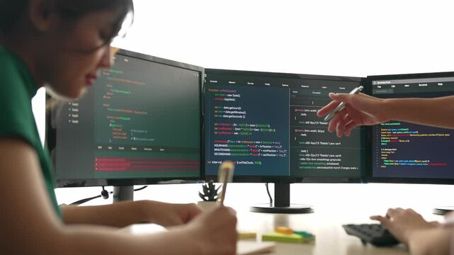 Back end software developer engineer for computer programming working together on debugging writing computing code, solving complex algorithms display on monitor in office. Burgeoning