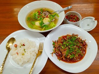 A simple yet satisfying Thai meal consisting of steamed rice, clear tofu soup, and spicy canned fish salad.